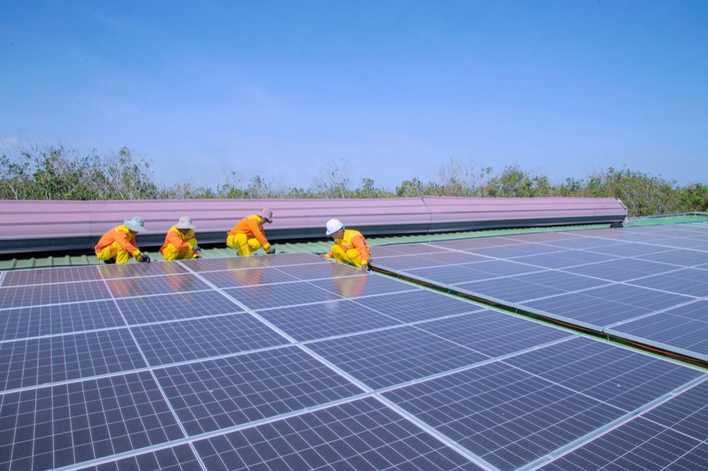 Crew in hi-vis working across a commercial solar roof